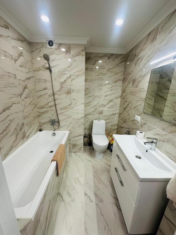 a bathroom with a tub and a sink and a toilet at Apartament Chişinǎu in Chişinău