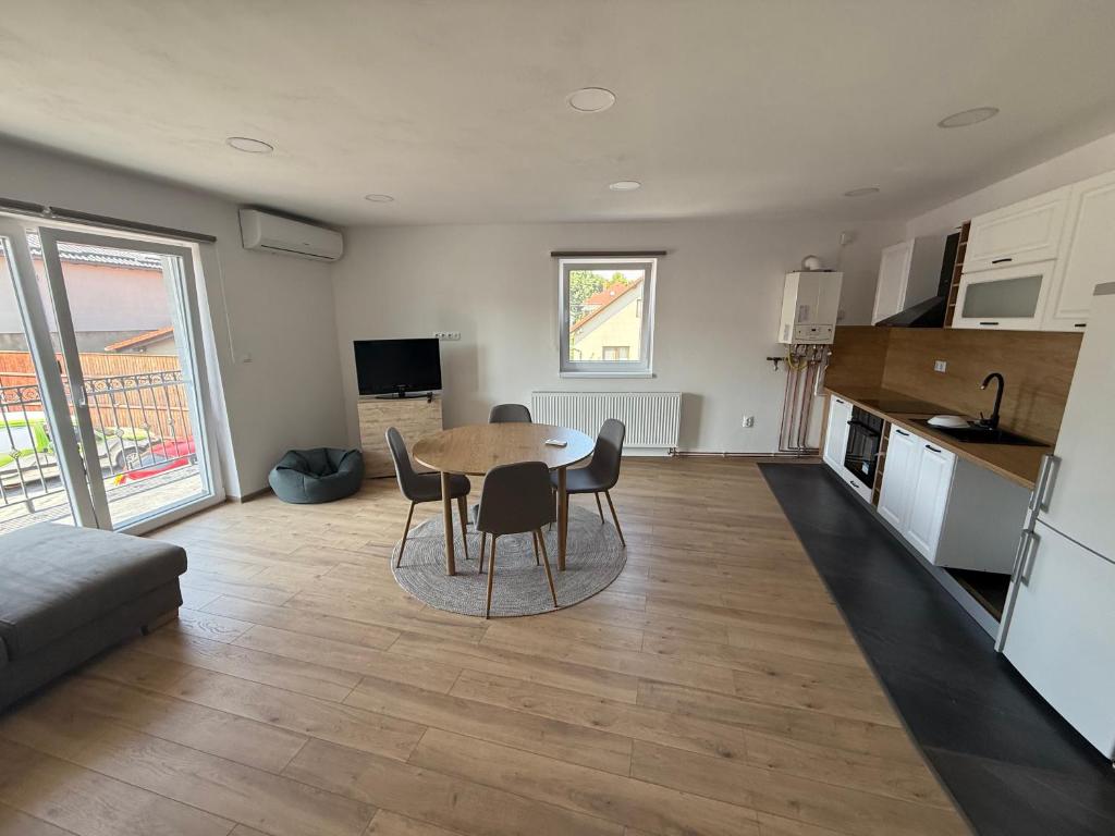 a kitchen and living room with a table and chairs at Bee apartman in Odorheiu Secuiesc