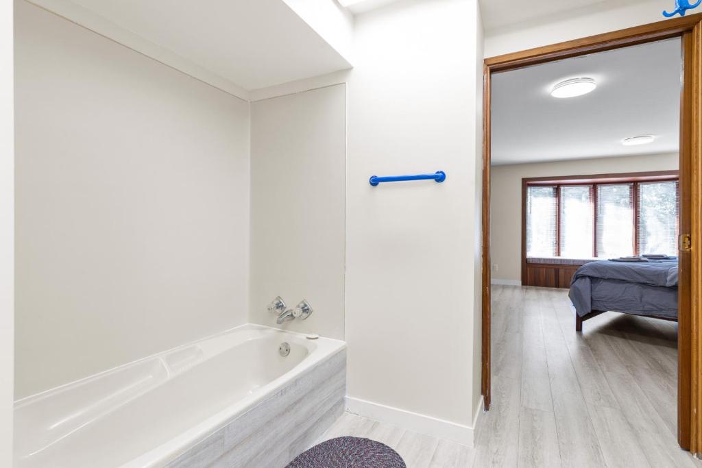 ein Bad mit einer Badewanne und ein Schlafzimmer in der Unterkunft Spacious and bright large suite with independent access in Delta