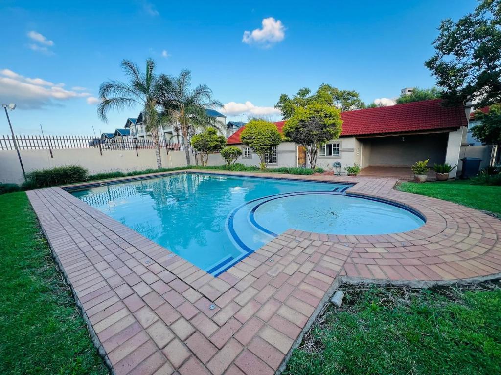 a swimming pool with a brick walkway around it at Mandy & Mos' Holiday Townhouse in Four Ways