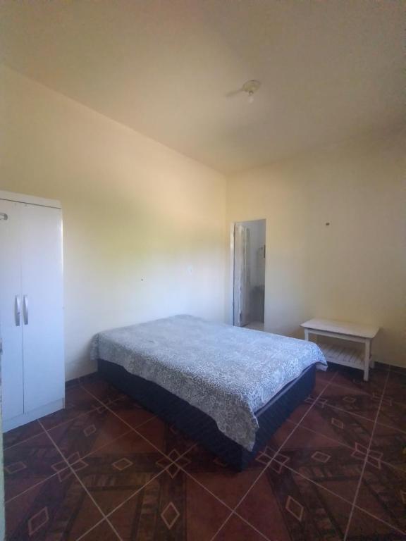 Un dormitorio con una cama en la esquina de una habitación. en Falésias de Marataizes, en Marataízes