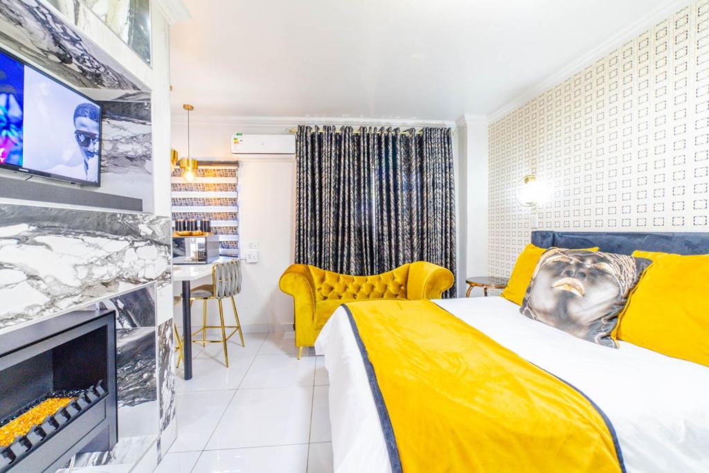 a hotel room with a yellow bed and a tv at Homes of Ace Diamond in Pretoria
