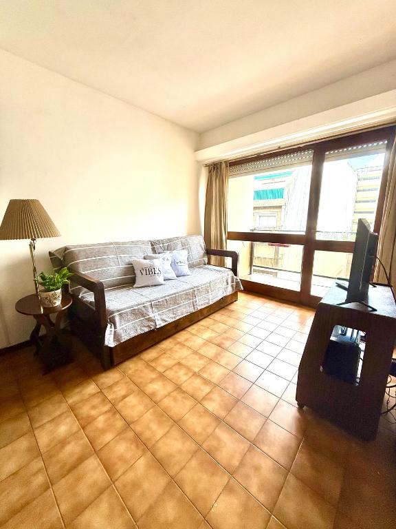 a living room with a couch and a large window at Amardel in Mar del Plata