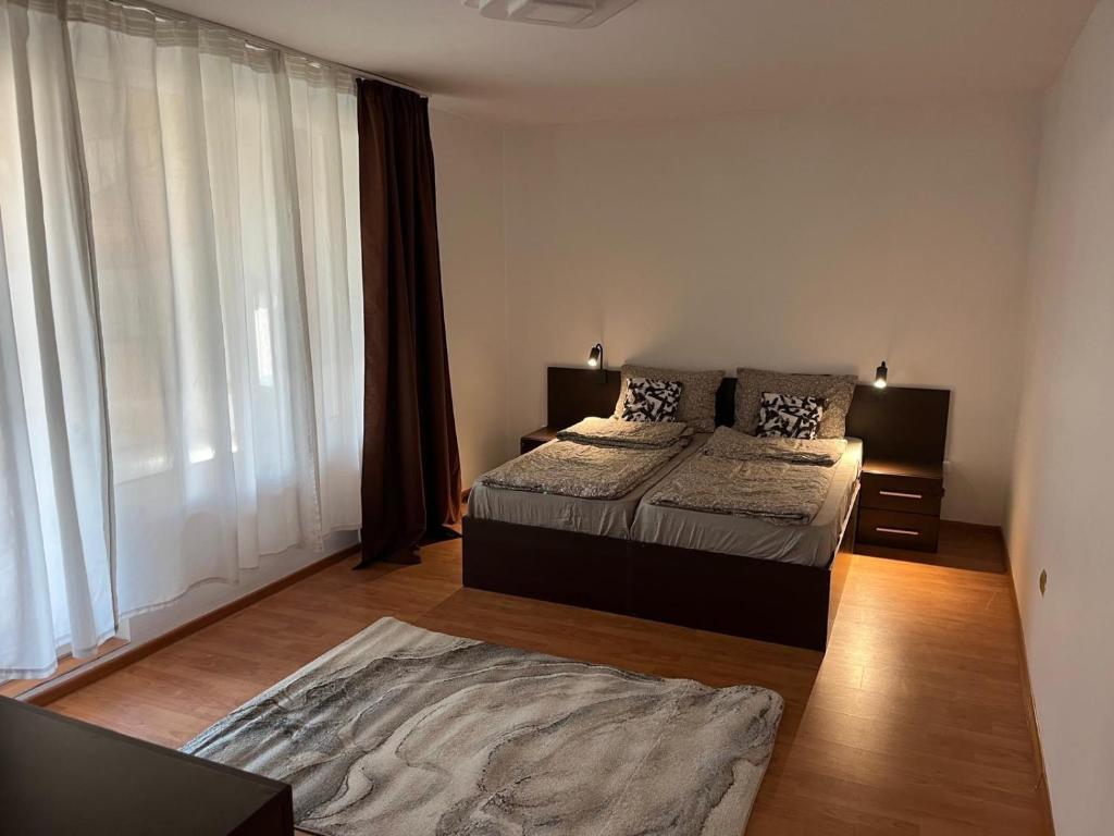 Un dormitorio con dos camas y una gran ventana. en Casa Raicu, en Ploieşti