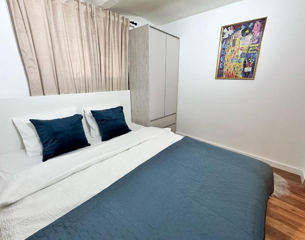 a bedroom with a large bed with blue pillows at URBAN BASE CELJE Apartment with FREE Parking & Terrace in Celje