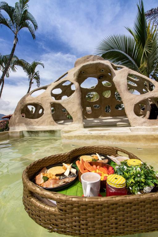 a basket of food in the water next to a pool at Hotel Glamping La Polka in Amagá