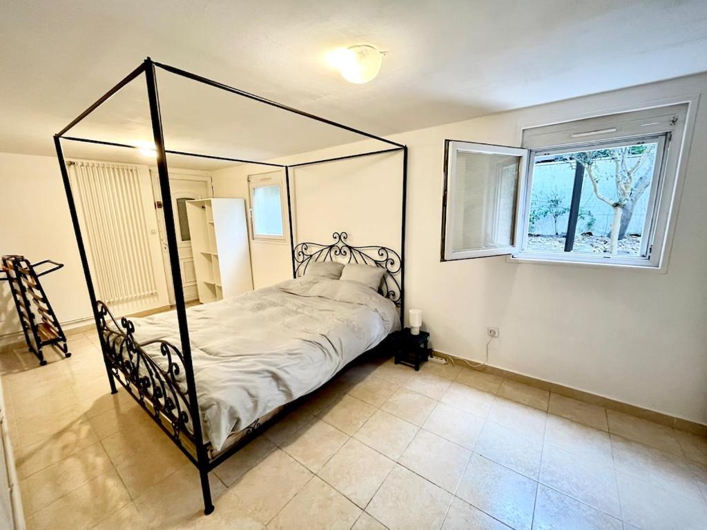 1 dormitorio con cama negra con dosel y ventana en Quiet in Bry, close to Paris & Disney, large room, en Bry-sur-Marne