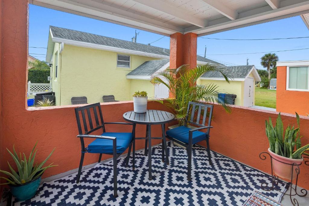 un patio avec deux chaises et une table sur un balcon dans l'établissement Holiday stays now available! Easy beach access!, à New Smyrna Beach