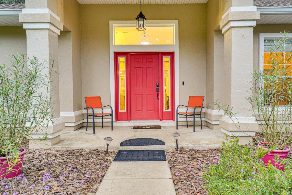 una porta d'ingresso rossa di una casa con due sedie di Great for Golfers and Equestrians! Refined Ocala Gem a Ocala Ridge