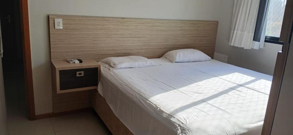 una camera con letto e testiera in legno di Apartamento 2 quartos COP 30 a Belém