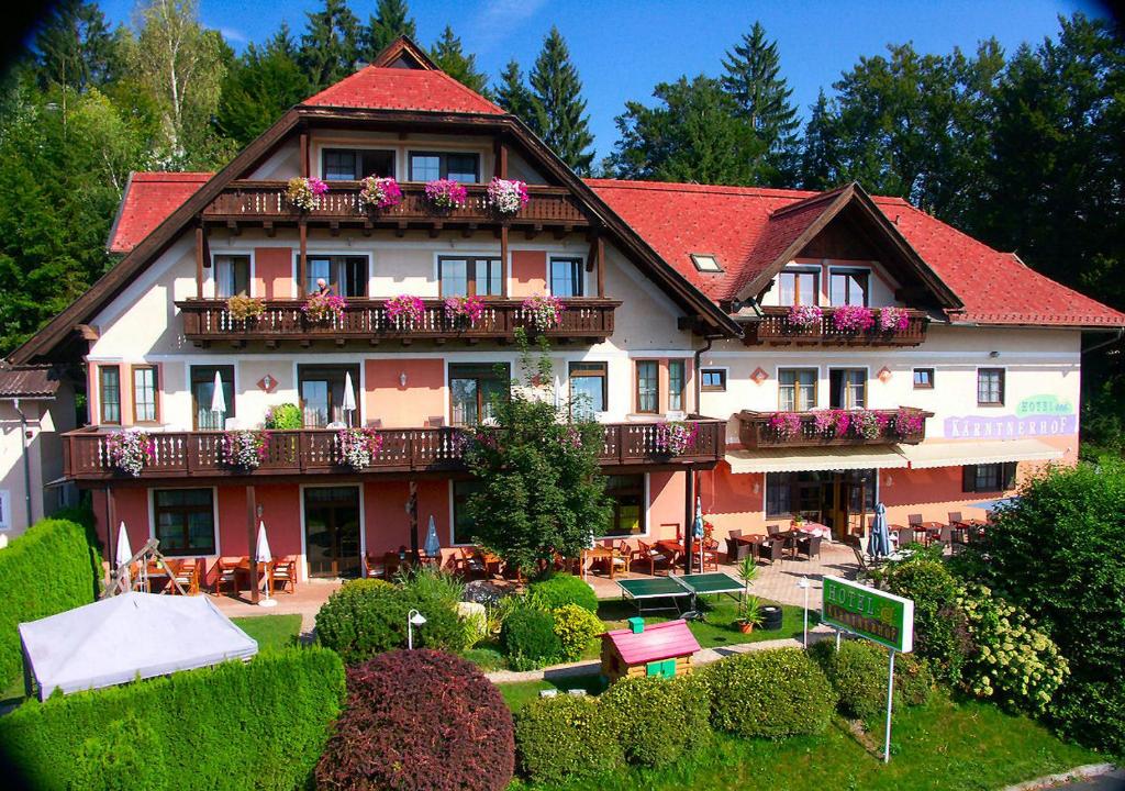 Una casa grande con flores en los balcones. en Hotel Kärntnerhof Velden, en Velden am Wörthersee