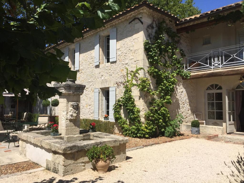a stone house with a fountain in front of it at La Banastiere in Vedène