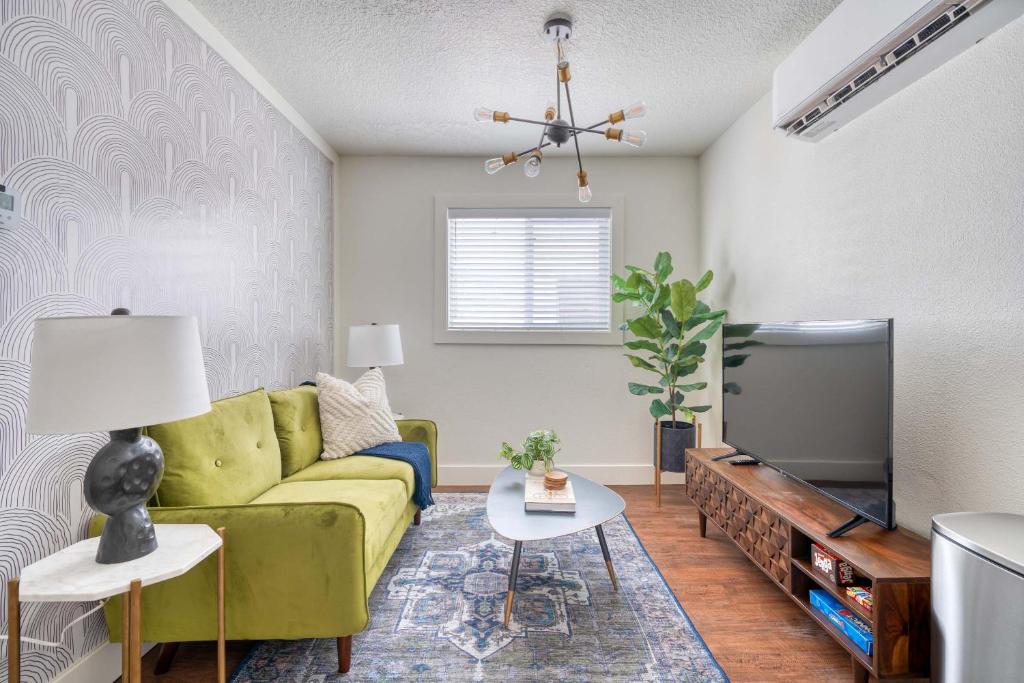 Una sala de estar con un sofá verde y un televisor. en Stay Portland - Beautiful Brooklyn 1 Bed Apt, en Portland