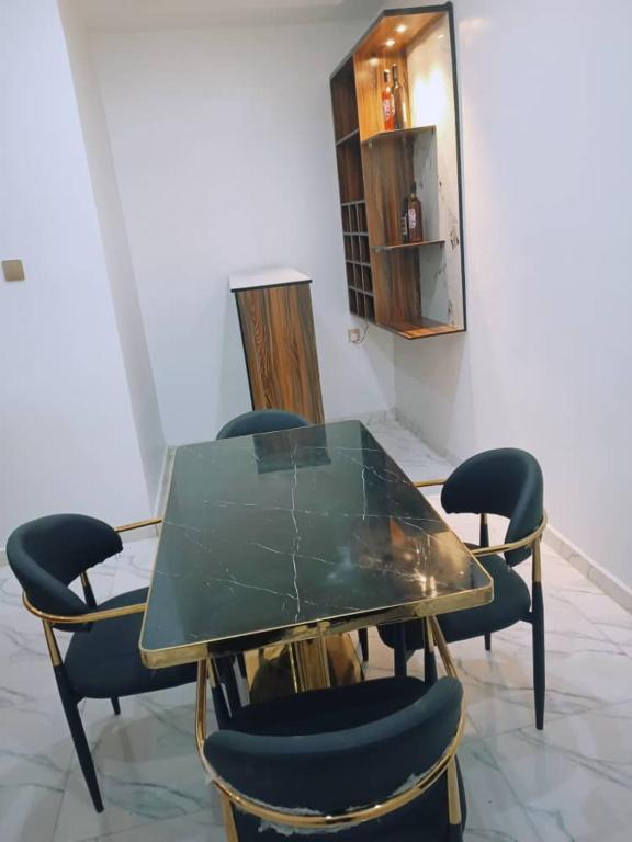 a glass table and chairs in a room at Ike Service Apartments in Owerri
