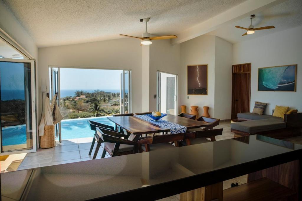 a kitchen and living room with a table and a couch at Casa Cumbres - Ocean View in Puerto Escondido