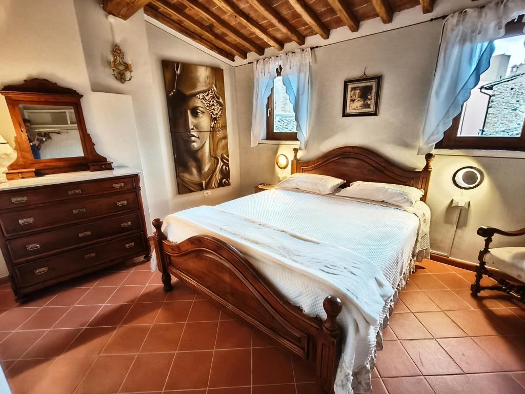 a bedroom with a bed with a dresser and a mirror at Amorosa Dimora in Certaldo