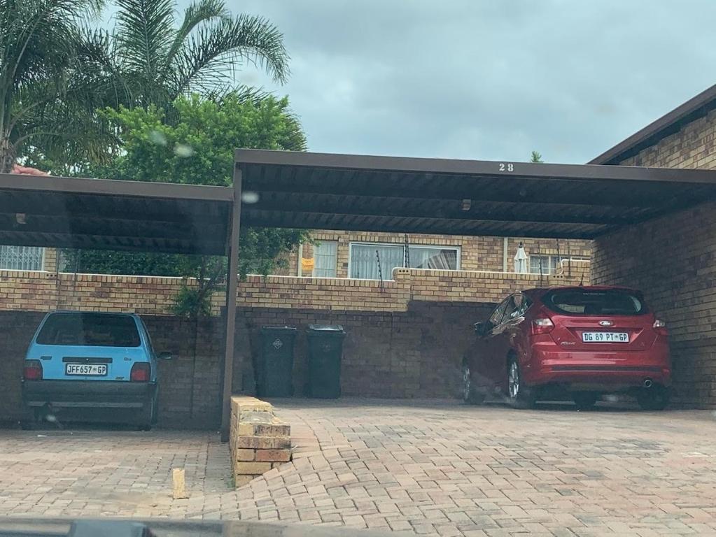 twee auto's staan geparkeerd op een parkeerplaats bij Central but hidden Gem in the Burbs in Northriding