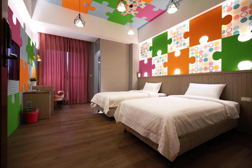 1 dormitorio con 2 camas y una pared colorida en Buckingham Palace B&B, en Beipu
