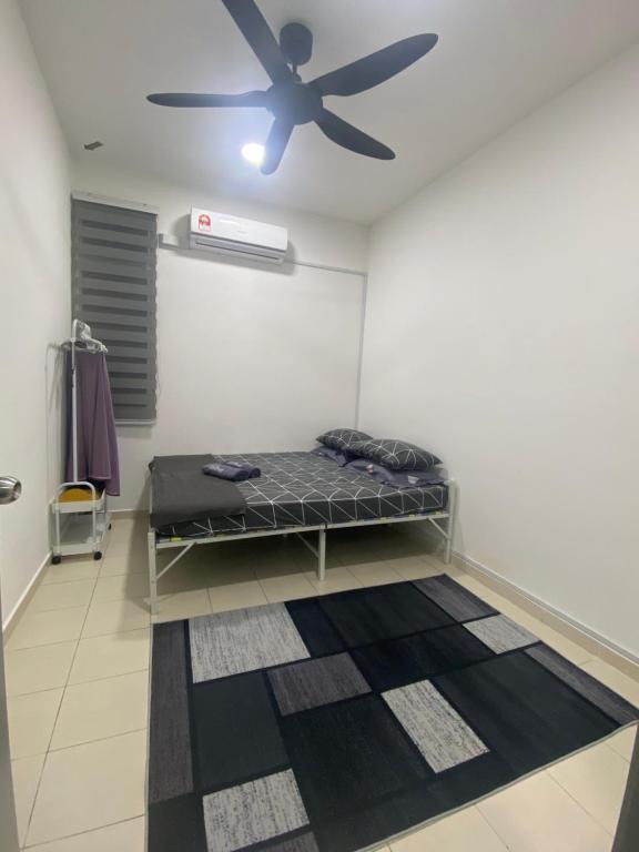 Cette chambre comprend un lit et un ventilateur de plafond. dans l'établissement Puncak Damai Homestay Alor Gajah, à Kampong Jelatang