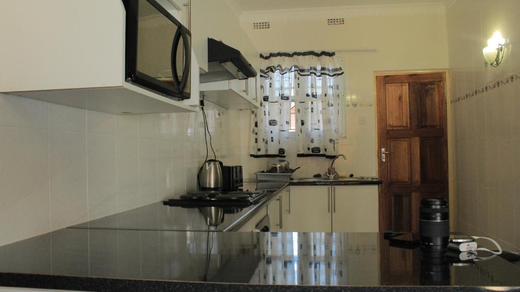eine Küche mit einer Spüle und einer Arbeitsplatte in der Unterkunft Asante Apartments in Livingstone