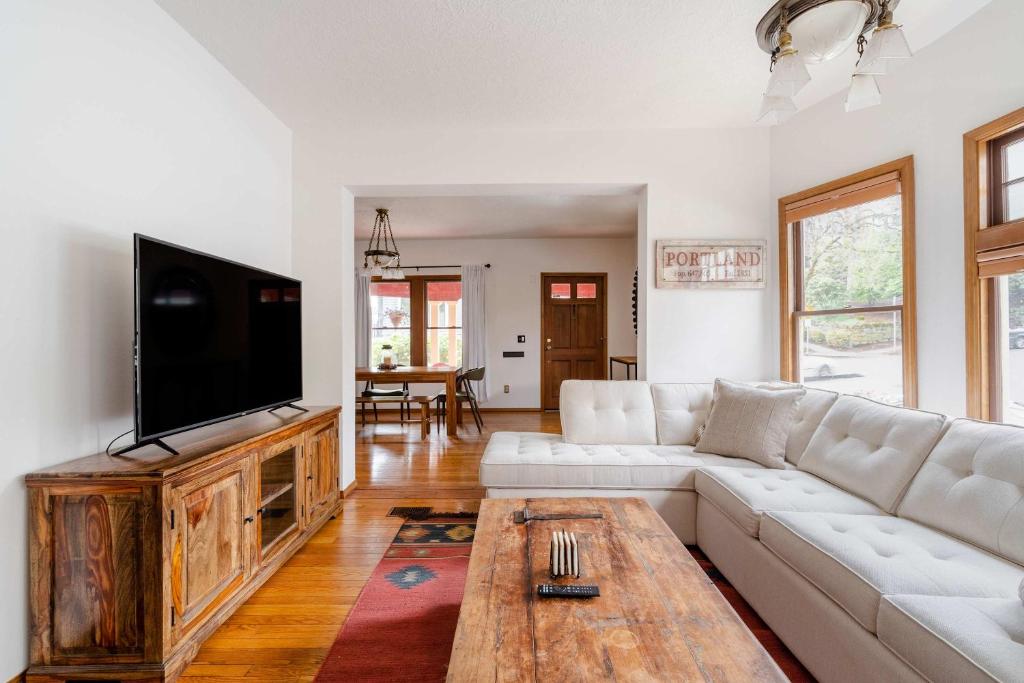 a living room with a white couch and a flat screen tv at Stay Portland - 3BR Craftsman - Vintage Charm - Great Location in Portland