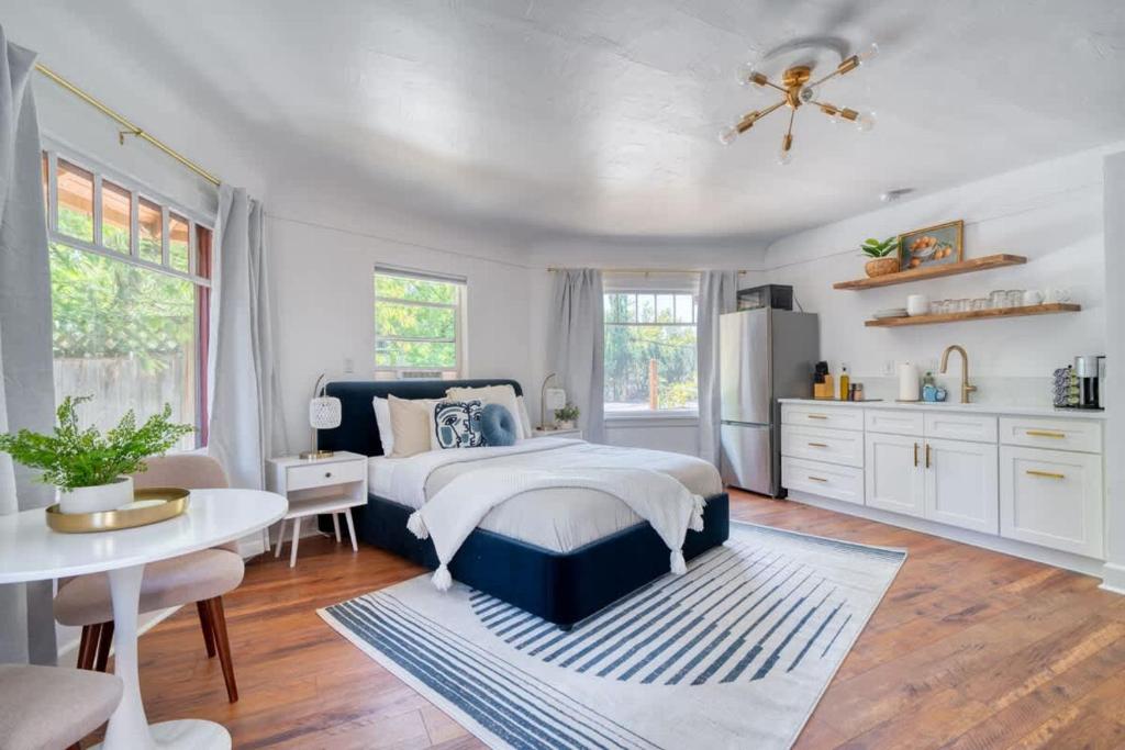 a bedroom with a bed and a table and a kitchen at Serene Forest Studio - Walk to Multnomah Village in Portland
