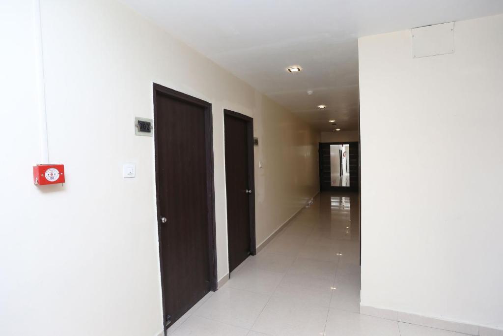 a hallway with two black doors and a white floor at Super Collection O R K International Near Gautam Buddha Park in Lucknow