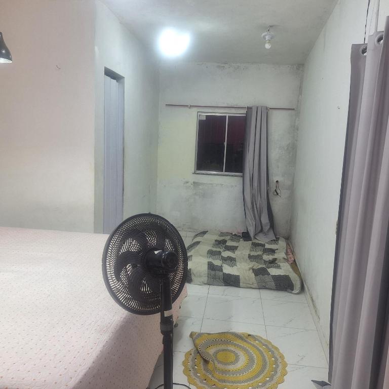 a bedroom with a fan next to a bed at Casa da D Luiza in Belém