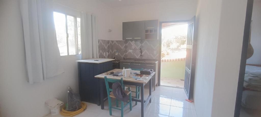 uma pequena cozinha com uma mesa e um fogão em Pousada Villa da Nascente em Florianópolis