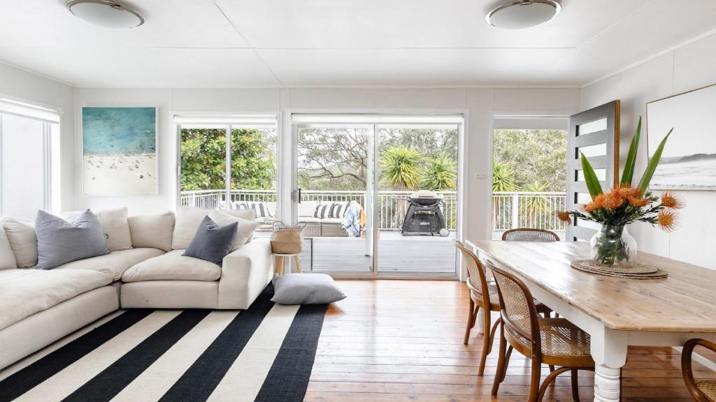a living room with a white couch and a table at Walk To Beach, Pet Friendly Trampoline in Pearl Beach