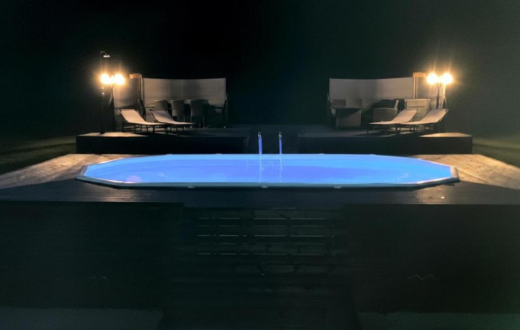 Una tina azul colocada encima de una mesa con sillas. en Cozy Home In Ansager With Sauna, en Ansager