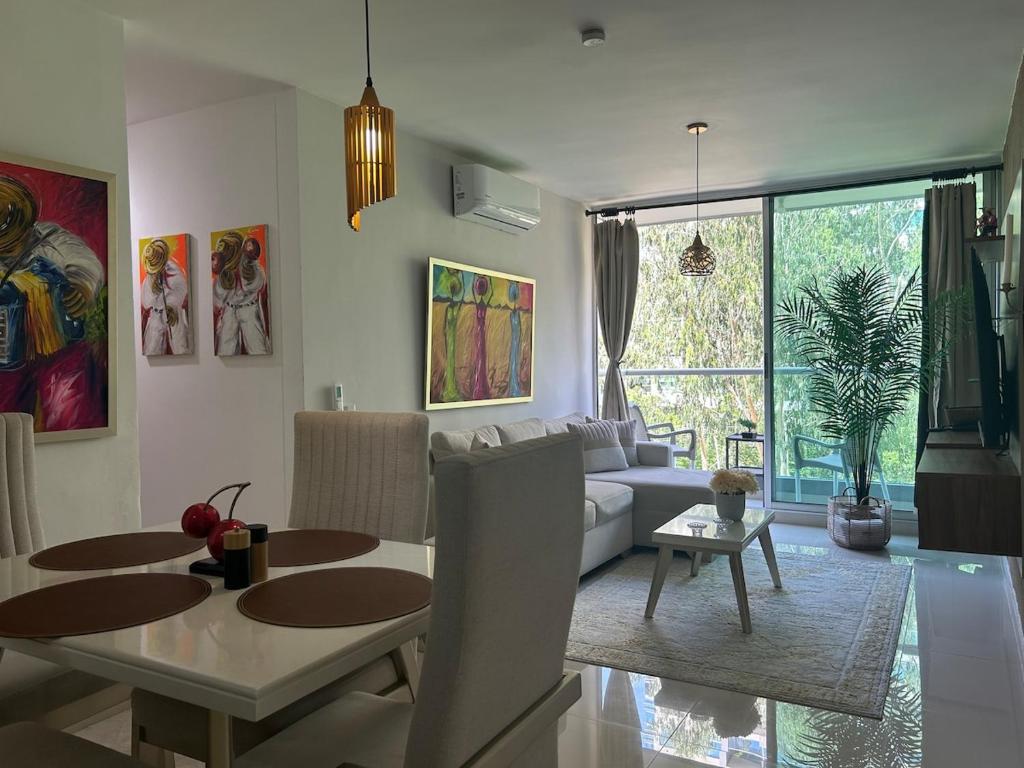 a living room with a couch and a dining room table at Confortable Apartamento in Barranquilla