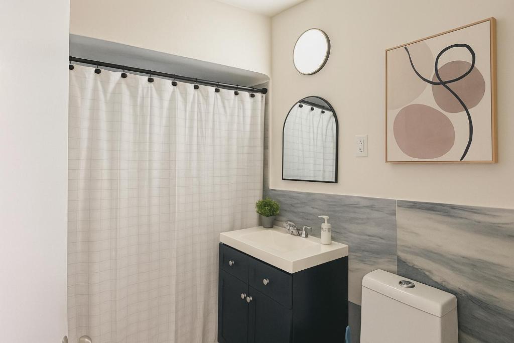 a bathroom with a sink and a shower curtain at The Awali in Miami