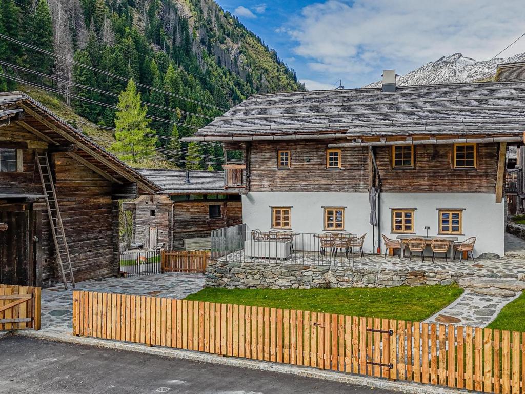 a log house with a patio and a table at Raneburg 4 Almhaus in Matrei in Osttirol