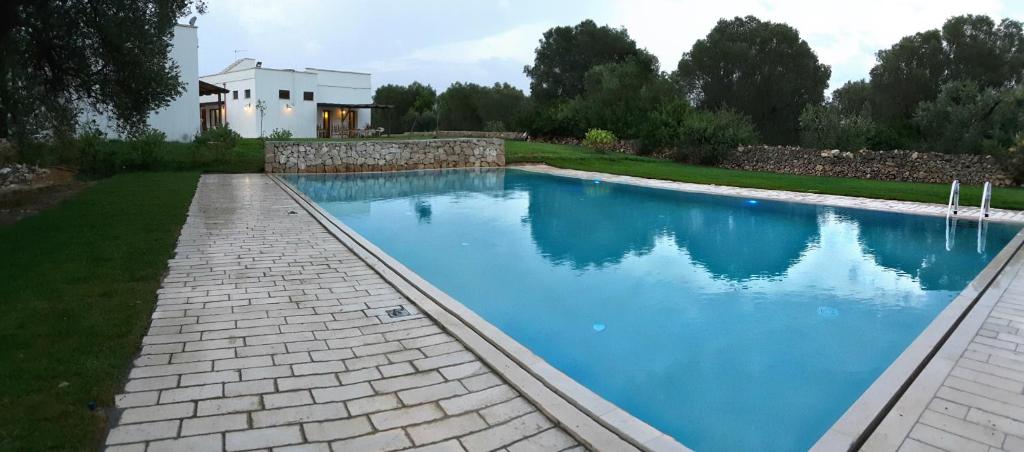 韋列的住宿－馬可尼農家樂，一座带房子的庭院内的游泳池
