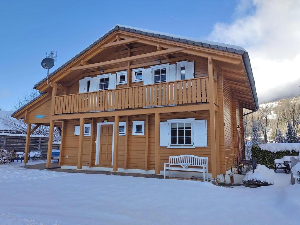 サン・ジャン・ドルプにあるLe Temps-Passeの雪の中にベンチ付きのログキャビン