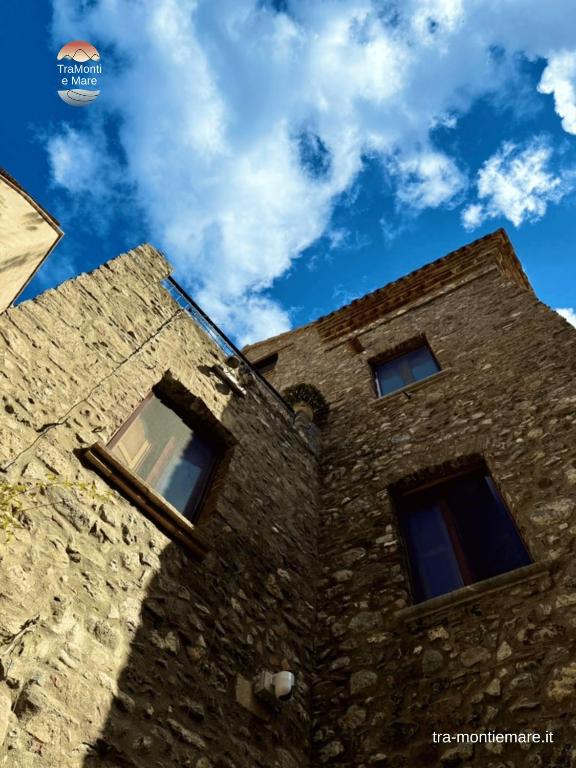 a stone building with three windows on the side of it at TraMonti e Mare in Scalea