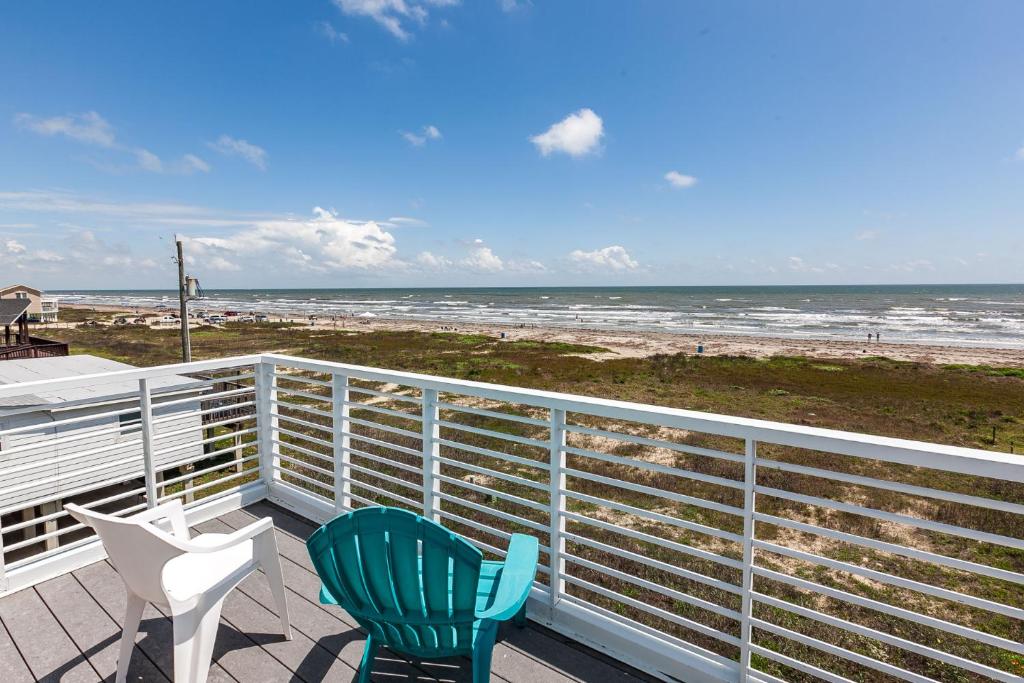 two chairs sitting on a balcony looking at the beach at Beachfront Melody in Galveston