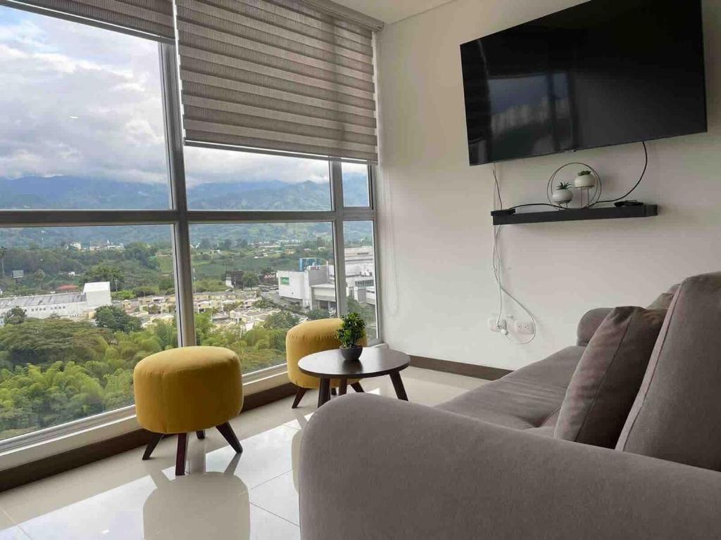 ein Wohnzimmer mit Couch und großem Fenster in der Unterkunft Apartamento norte de Armenia, piso 12 con zona social completa in Armenia