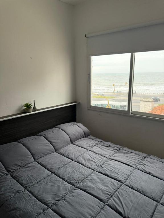 a bedroom with a bed with a view of the beach at Hotel&Vermú AREIA a metros del mar in Mar del Plata