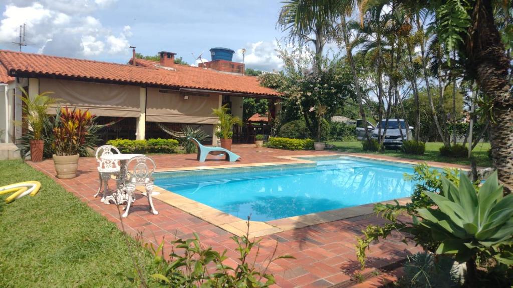 une piscine dans l'arrière-cour d'une maison dans l'établissement Chalés Paraíso Verde, à Itatiaia