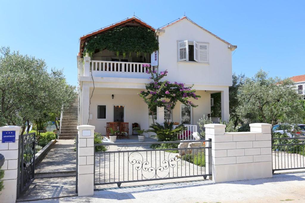 a white house with a gate in front of it at Apartment Ston 10226a in Mali Ston