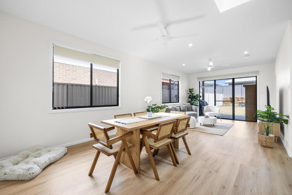 a living room with a wooden table and chairs at Sand and Soul with Infrared Sauna in South West Rocks