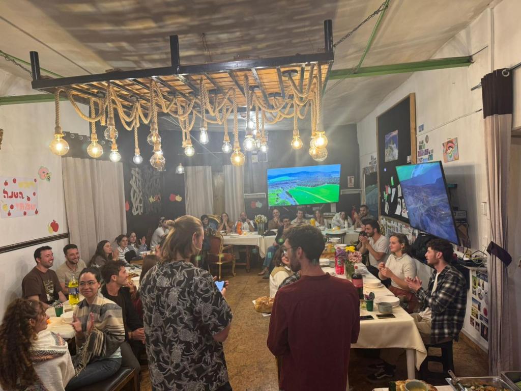 a group of people sitting at tables in a room at Bardak hostel in Cusco