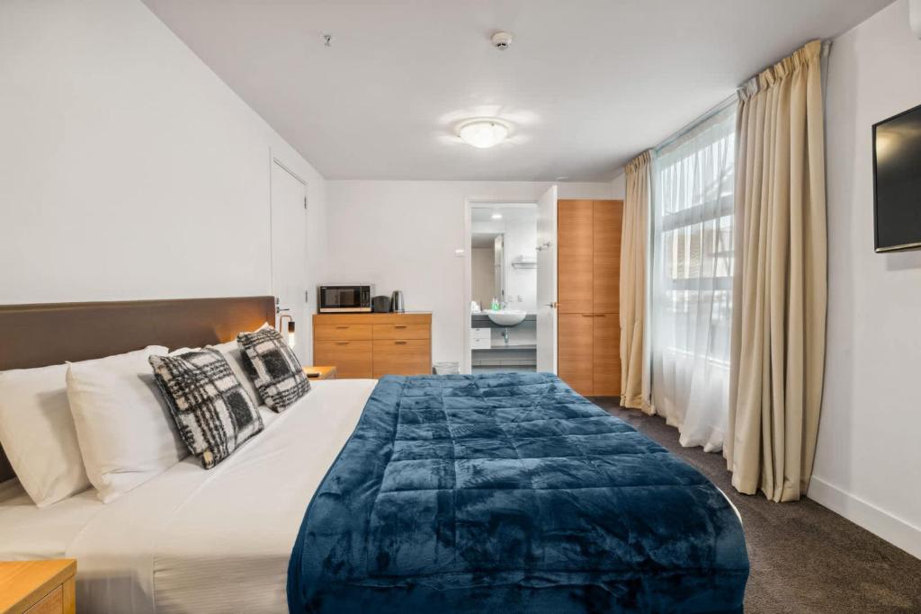Un dormitorio con una cama grande y una ventana. en Waterfront Queenstown Studio Peaceful Stay, en Frankton