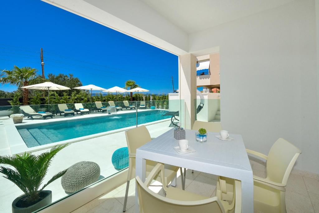 a living room with a table and chairs and a pool at Luxury Apartment 1 Villa Arta in Bibinje