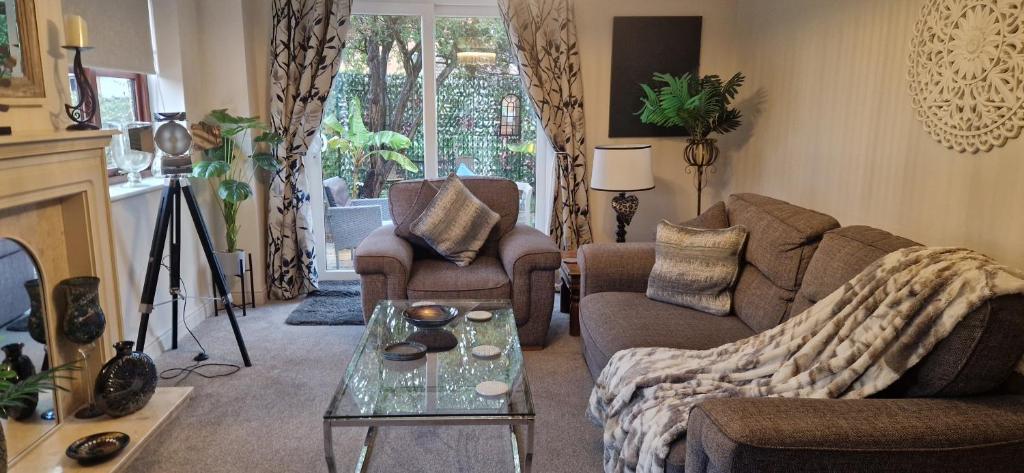 un salon avec un canapé et une table dans l'établissement Stunning Fir Trees Corner 3 bedroom detached Executive house with free drive way parking for 2 vehicles 1 mile from M5 dogs welcome, à Worcester