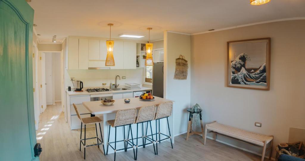 a kitchen with a table and some chairs in a room at casa ikigai in Curacautín