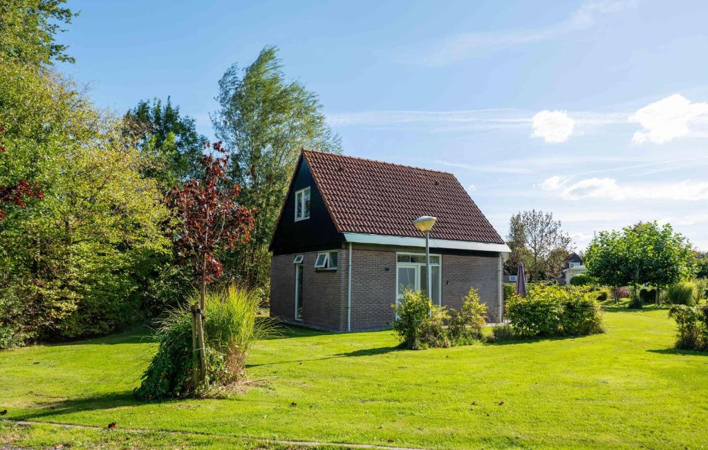 een klein huis in een tuin met een groen gazon bij Gorgeous Home In Woudsend With Wifi in Woudsend