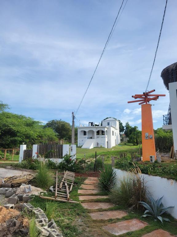 una casa con un molino de viento delante en Dragonfly, en Treasure Beach